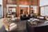 Luxurious and inviting living area featuring rich wooden paneling, elegant seating, and stylish decor with a modern reception counter.