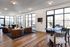 Bright and modern lounge area with large windows, cozy leather chairs, and stylish decor, offering a welcoming and vibrant atmosphere.