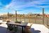 Expansive rooftop terrace with stylish seating offers stunning river and city skyline views under a vibrant blue sky.