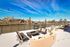 Vibrant rooftop patio with stylish lounge seating and stunning river views, framed by cityscape and clear blue skies.