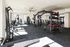 Bright and modern fitness center featuring a variety of exercise equipment including weights, a punching bag, and rowing machine, ideal for an energizing workout.