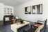 Modern living room with sleek black furniture, abstract art on the walls, and a cozy ambiance, ideal for stylish urban living.