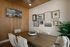 Elegant dining room with chic wall art, featuring a wooden table and plush white chairs, enhanced by a stylish chandelier.
