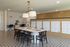 Elegant co-working space with a modern design, featuring a large table, stylish chairs, decorative lighting, and vibrant patterned flooring.
