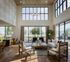 Elegant modern living room with high ceilings, large windows, and stylish furnishings, offering abundant natural light and a warm, inviting atmosphere.