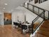 Sleek modern apartment lounge featuring a stylish wooden staircase, elegant seating area, and chic decor with motivational art.