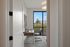 Inviting home office with modern wood desk, sleek chair, and large window offering natural light and garden views.