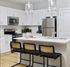 Modern kitchen with sleek white cabinets, stainless steel appliances, and an inviting island with stylish pendant lighting.