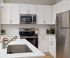 Modern kitchen boasting sleek stainless steel appliances, elegant white cabinetry, and a spacious island, perfect for culinary creativity.