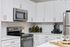 Modern kitchen with sleek stainless steel appliances, white cabinetry, and elegant subway tile backsplash, ideal for gourmet cooking and entertaining.