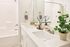 Elegant bathroom featuring double sinks, a sleek marble countertop, and refreshing greenery for a touch of nature.