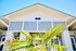 Charming modern facade with vibrant blue accents and tropical palm detail, offering inviting curb appeal.