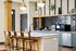 Modern kitchen featuring a stylish island with elegant pendant lights, sleek cabinetry, and contemporary bar stools.