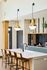 Modern kitchen with elegant pendant lighting, sleek marble countertops, and stylish bar stools for a sophisticated touch.