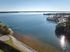 Scenic lakeside view with a sparkling blue expanse, lush greenery, and a peaceful dock inviting serene outdoor living.