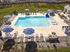 Luxurious outdoor pool area featuring elegant loungers, chic umbrellas, and stylish patio seating, ideal for relaxation and leisure.