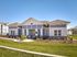 Charming modern building with a landscaped front yard and bright blue sky, perfect for a welcoming community atmosphere.