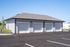 Modern apartment complex featuring spacious four-car garage with pristine white doors and elegant landscaping.