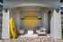Chic patio entrance with stylish seating beneath a welcoming 'Boathouse' sign, complete with a vibrant yellow kayak adding a splash of color.