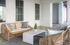 Chic outdoor patio featuring elegant wicker furniture and modern touches, perfect for relaxing in style.