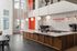 Modern coffee shop interior with sleek spiral staircase, chic light fixtures, and stylish bar area at Trapeze Coffee.