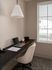 Elegant home office nook with sleek black desk, cozy beige chair, and large window offering natural light, perfect for productivity.