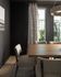 Chic dining area with a modern wooden table, beige upholstered chairs, and elegant floor-to-ceiling windows offering natural light and views of lush greenery.