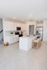 Modern kitchen with sleek white cabinetry, stainless steel appliances, and a stylish island bar with seating, perfect for entertaining.