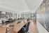 Modern communal living space with elegant decor, featuring large artwork, sleek furniture, and abundant natural light.