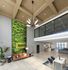 Luxurious apartment lobby with modern decor, a vibrant green wall, and stylish seating area under a stunning chandelier.