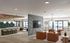 Modern open-concept apartment featuring chic lounge area with leather chairs, stylish lighting, and a sleek kitchen with bar seating.