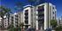 Modern apartment complex featuring elegant balconies, lush palm trees, and ample parking in a vibrant urban setting.