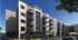 Modern apartment complex with stylish balconies, lush landscaping, and inviting outdoor pool area under a clear blue sky.
