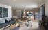 Modern open-concept living room with sleek kitchen island, elegant decor, and cozy seating area.
