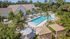 Luxurious apartment complex with a stunning pool surrounded by tropical palm trees and stylish cabanas, offering a perfect oasis for relaxation.