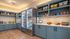Inviting pantry space featuring sleek blue cabinets, a variety of snacks, and a modern refrigerated beverage section.