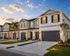 Charming suburban townhouse with elegant gray facade and inviting front lawns at sunset.