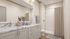Elegant bathroom with a marble-topped vanity, chic lighting, and a decorative vase, showcasing a modern shower area and cozy bath elements.