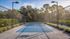 Inviting outdoor tennis court surrounded by lush greenery, perfect for sports enthusiasts and nature lovers.