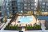 Modern apartment complex featuring a luxurious swimming pool surrounded by chic lounge chairs, set against a backdrop of stylish multi-story buildings.