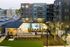Modern apartment complex exterior featuring a swimming pool, stylish outdoor seating, and lush landscaping.