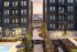 Modern apartment complex courtyard with lush landscaping, evening lights, and inviting pathways.