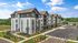 Modern apartment complex with stylish architecture, manicured landscaping, and ample parking under a bright blue sky.