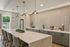 Elegant modern kitchen with chic pendant lighting, sleek marble island, and stylish geometric backsplash.