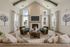 Bright and elegant living room with high ceilings, a modern fireplace, and cozy seating, perfect for relaxation and entertaining.