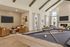 Inviting living area with a vaulted ceiling, featuring a stylish pool table, cozy seating with leather chairs, and a modern fireplace.