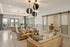 Elegant and spacious living area with modern lighting fixtures, cozy seating, and large windows offering natural light.