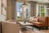 Inviting living space with elegant brown leather seating and large windows offering abundant natural light.