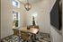 Bright conference room with modern decor, featuring a stylish chandelier, large windows, and a sleek table with executive chairs.