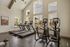 Modern fitness center with state-of-the-art treadmills and ellipticals, large windows offering natural light and picturesque views.